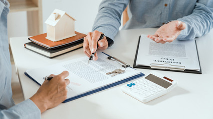 broker agent and customer holding pen, the policyholder and explain discussing for concerning mortgage loan offer for and house insurance.
