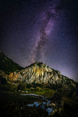The Milky Way over the lit mountain volcano. Greece. Khalkidhiki