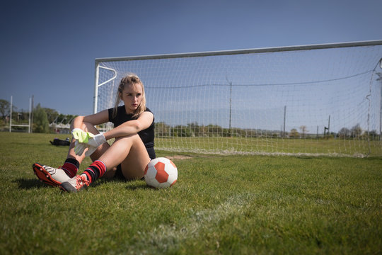 Female soccer player relaxing on field - Powered by Adobe