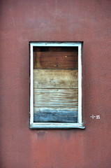 Boarded Window on Red Stucco Wall