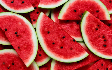 A large number of cut slices of watermelon - Powered by Adobe