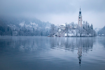 Lake Bled in winter season with snow and tourist boats
