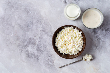 .Fermented milk. Cottage cheese in a bowl of coconut, milk and yogurt with cereals and dried fruits on a marble background. View from above