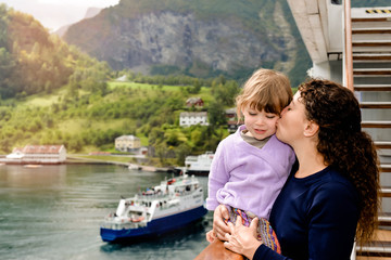 pretty little girl and her mom on a boat in the middle of the fjords