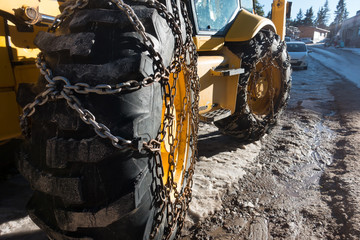 Snow chains have been fitted to heavy duty tyres of a snow clearing vehicle.Image