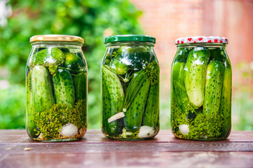 Homemade marinated cucumbers in glass jars on the table.