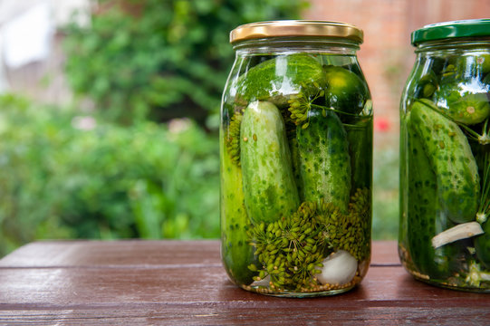 Homemade marinated cucumbers in glass jars on the table.