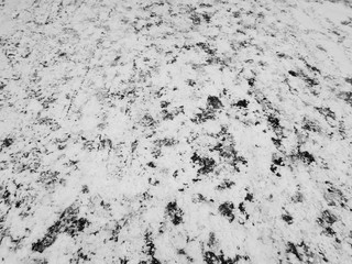 Asphalt road in the snow. Footprints in the snow.