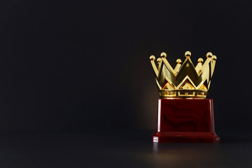 image of golden crown award over wooden table.