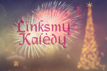 "Linksmų Kalėdų"means "Merry Christmas" in Lithuanian. Blurred background of decorated Christmas tree with golden lights. Fireworks. Bokeh. Celebration 25 December. 2020. Greeting card Lithuania.