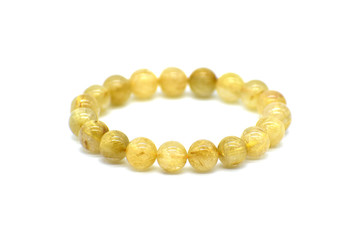 Golden rutilated quartz bracelet on white background. Selective focus at the front of the bracelet...