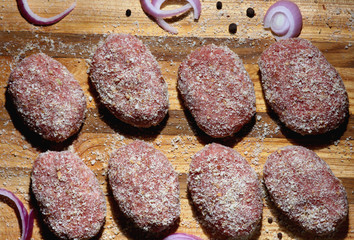 meat cutlets laid out in a row on a wooden Board