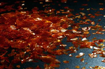 natural shellac flakes in a beam of light on a dark background