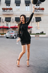 Obraz premium Full-length portrait of slim tall woman with helium balloons enjoying life in big city. Outdoor photo of enthusiastic brunette girl in beautiful dress having fun at birthday party.