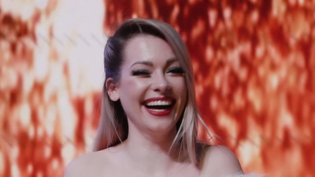 Attractive santa girl is laughing. Beautiful blonde celebrating Christmas or New Year on a blurred background. Happy beautiful woman smiling and having fun slow motion
