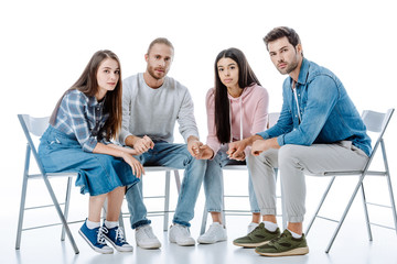 multicultural support group sitting on chairs isolated on white