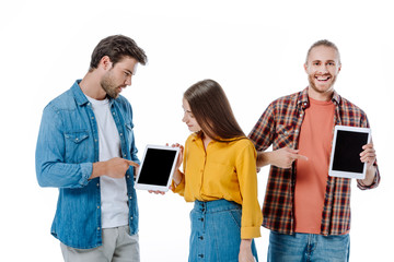 three young friends looking at digital tablets isolated on white