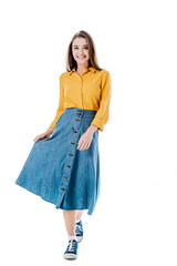 Fototapeta premium full length view of smiling attractive girl holding denim skirt isolated on white
