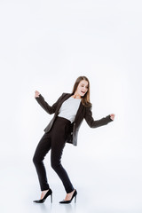 full length view of happy businesswoman in suit posing isolated on white
