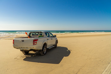 Fototapeta na wymiar there's a white pickup truck on Fraser Island beach..