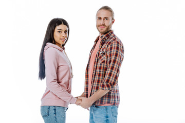 smiling young interracial couple holding hands isolated on white