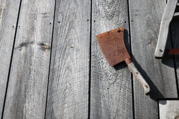 Old rusty wooden hand tools hanging on door of rustic weathered barn