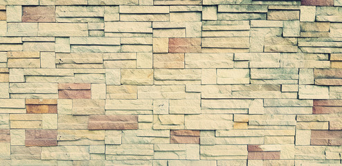 Pattern of yellow brick wall for background in vintage tone. Art wallpaper and Architecture Exterior design concept