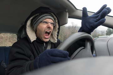 Angry man with screaming into car in winter time