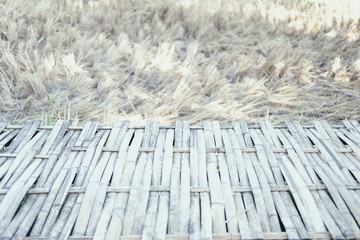wooden footbridge in rice straw hay paddy field
