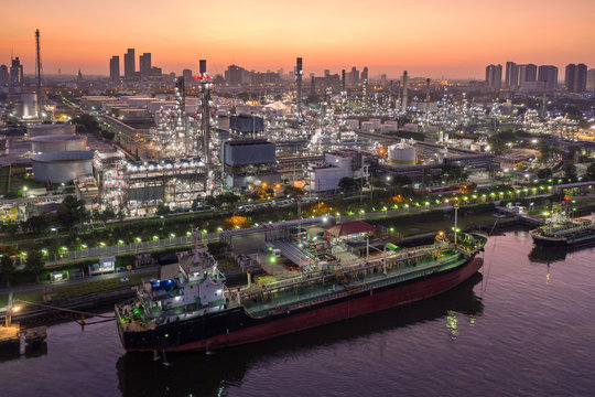 Aerial view Oil ship tanker load or unload oil at loading dock from refinery at dusk.
