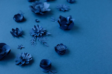 Blue paper flowers on blue background. Cut from paper.