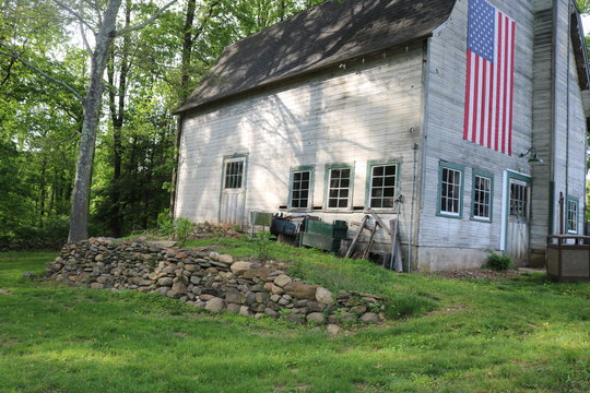 Old weathered wooden historic barn with American flag