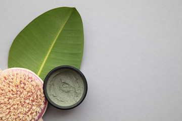 Organic natural cosmetic product with a green leaf on a grey background