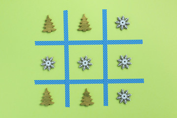 New Year tic tac toe game, isolated on green background. Christmas, winter concept. Flat lay, top...