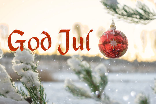 "God Jul" means "Merry Christmas" in Swedish and Norwegian. Blurred background of beautiful Christmas tree in snowfall decorated with red ball. Bokeh Forest Snow. Happy New Year 2020 Sweden Norway.
