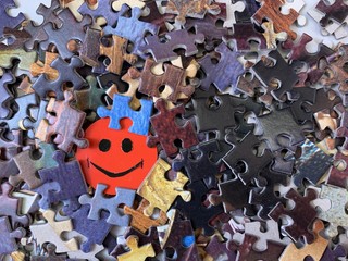 Image of a happy face on cardboard. Puzzle in the details in the form of a mosaic. Concept: joy, happiness, positive, kindness.