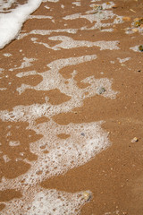 trail of water on the sand of the shore of a reservoir