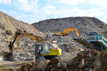 Salvaging and recycling building and construction materials. Excavator with hydraulic hammer work...