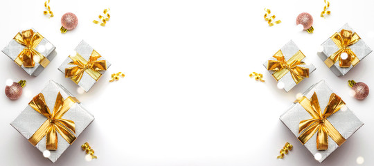 Obraz premium New years background. Christmas gifts with gold ribbon on white background. Xmas present. Winter holiday concept. Merry Christmas and Happy Holidays greeting card, frame, banner