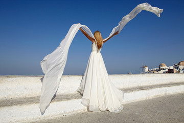 Fototapeta na wymiar Bride playing with heri veil in Santorini, Greece