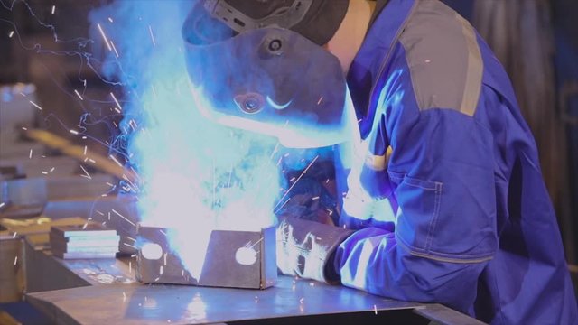 Bright sparks from a welding machine slowmotion. Slowmotion welding close-up