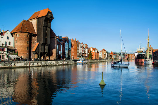 Famous historic Medieval port Crane (Żuraw / Krantor) - one of the Gdańsk water gates. Sunny morning on the Motlava River. Old town Gdansk (Gdańsk / Danzig), Poland
