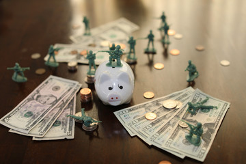 Toy soldiers guarding money and piggy bank