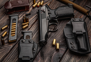 A modern black pistol and ammunition on dark metal background. Weapons for police, army, special forces.