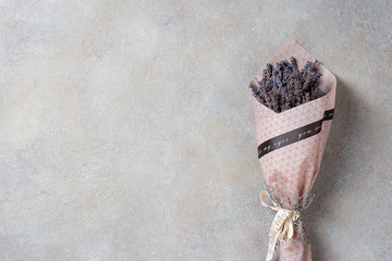 One small bouquet of lavender on a light concrete background with copy space.