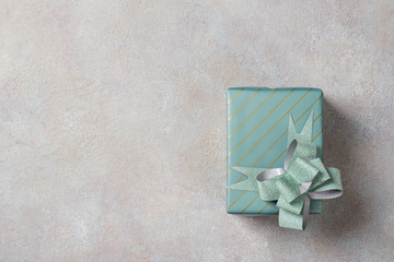 One gift box in turquoise packaging on a light concrete background.