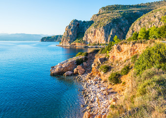 Greek coastline with rocky cliffs and pebble beaches near Nafplio town