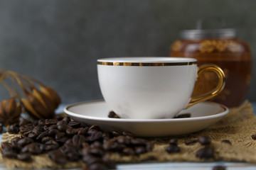 White coffee cups and roasted coffee beans On the sack