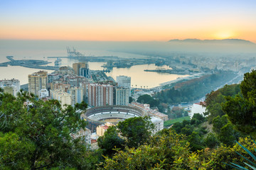 Fototapeta premium Center of the Spanish city of Malaga. Sunset with blue sky on the Costa del Sol of the city, the port, the houses, the trees, the bullring