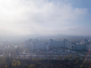 Foggy morning above city district.